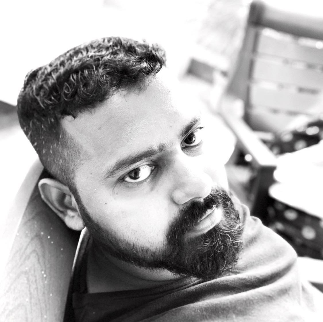 Black and white close-up photo of a bearded man looking intently at the camera.